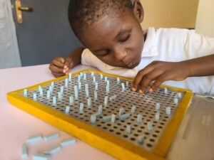 A photo of our champion preparing for braille reading and writing